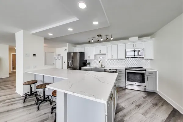 a kitchen with a stove a refrigerator and a dining table