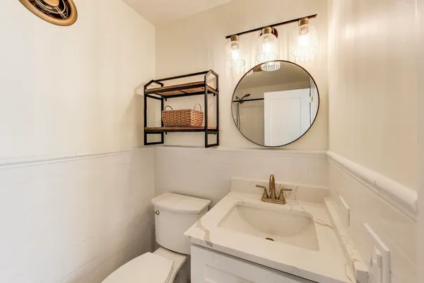 a bathroom with a sink mirror and toilet