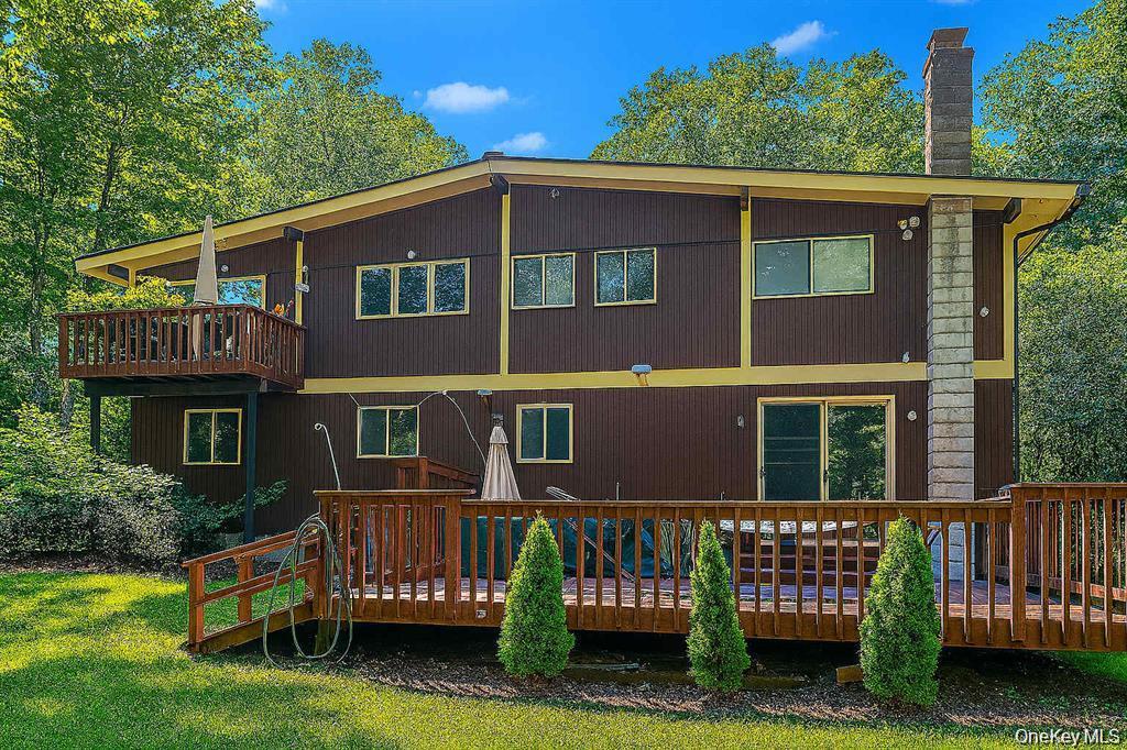 249 Mill River Road Chappaqua, NY 10514 - Photo 2 of 33 Multi-level exterior featuring brown vertical siding, yellow trim, and multiple windows