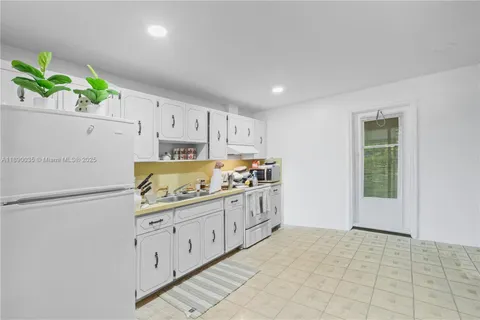 a kitchen with granite countertop a stove a sink and a refrigerator