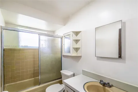 a bathroom with a shower a toilet and a sink