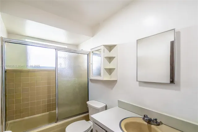 a bathroom with a shower a toilet and a sink