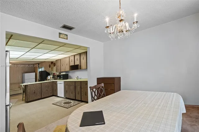 a bed room with a bed mirror and a chandelier