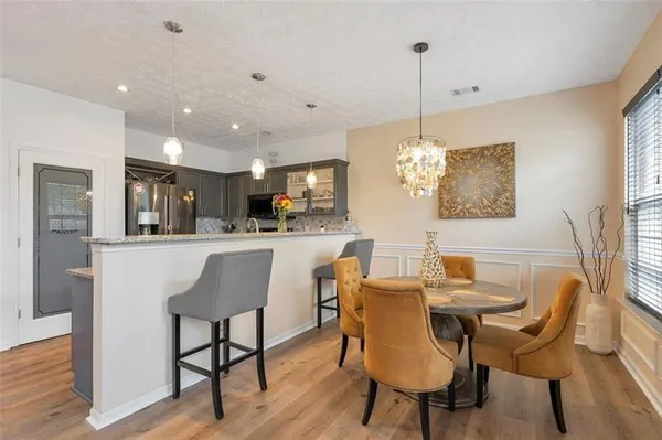 a dining room filled chandelier and wooden floor