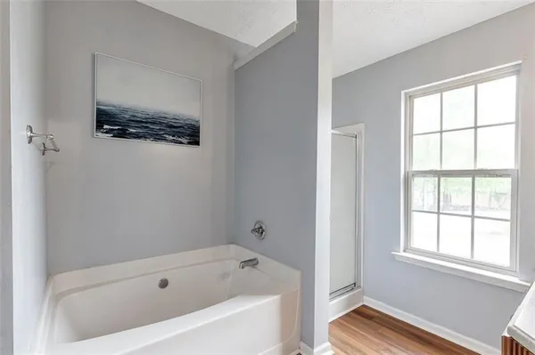 a bathroom with a tub a sink and a window