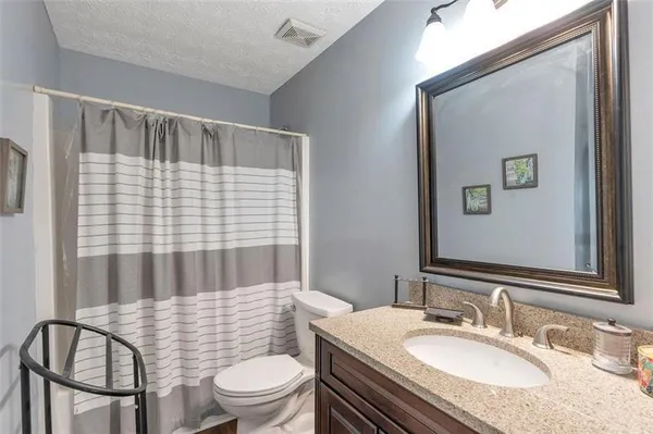 a bathroom with a sink toilet a mirror and shower