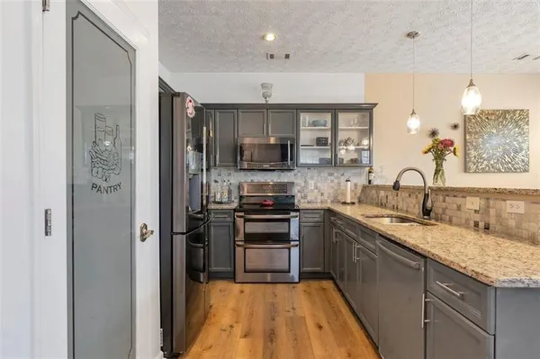 a kitchen with stainless steel appliances granite countertop a sink and a stove