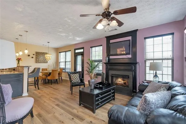 a living room with furniture fireplace and a large window