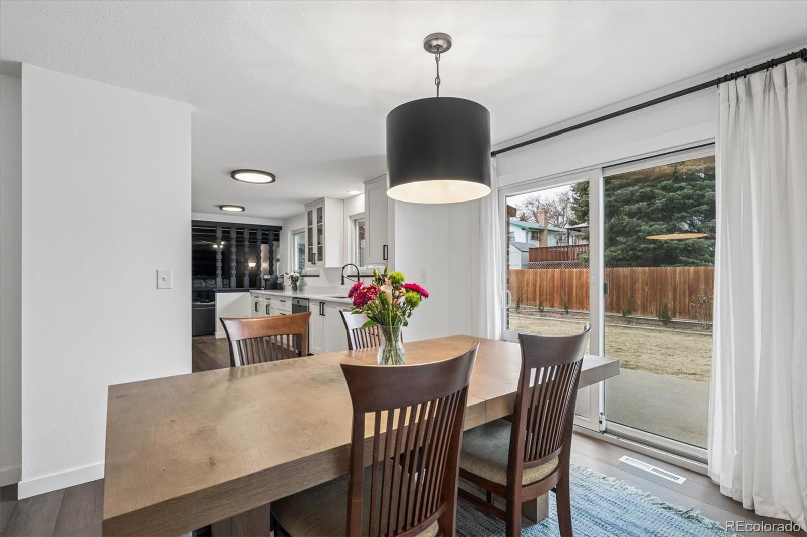 8257 Yarrow Court Arvada, CO 80005 - Photo 19 of 38 a dining room with furniture potted plants and wooden floor
