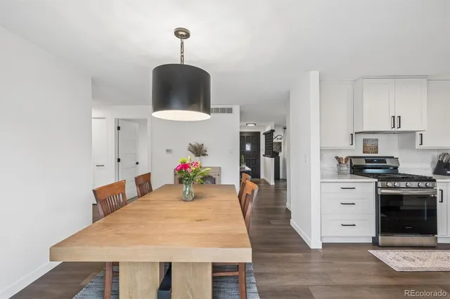 a view of a kitchen with a stove wooden floor and a living room