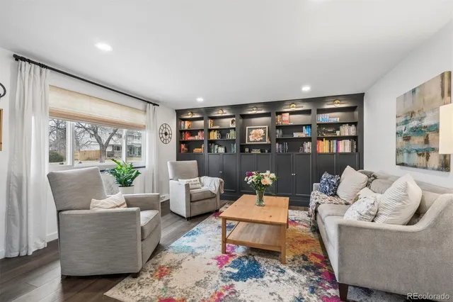 a living room with furniture and a book shelf