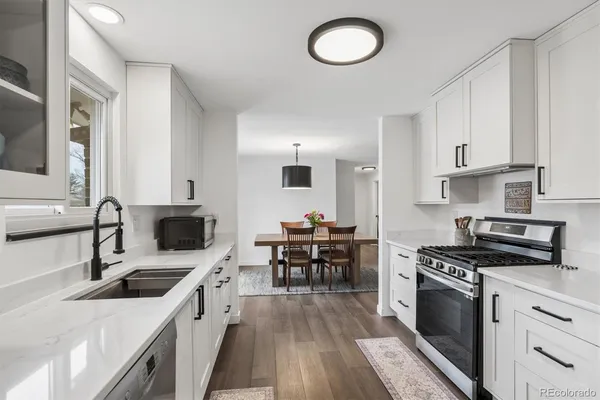 a kitchen with stainless steel appliances a stove sink microwave and cabinets