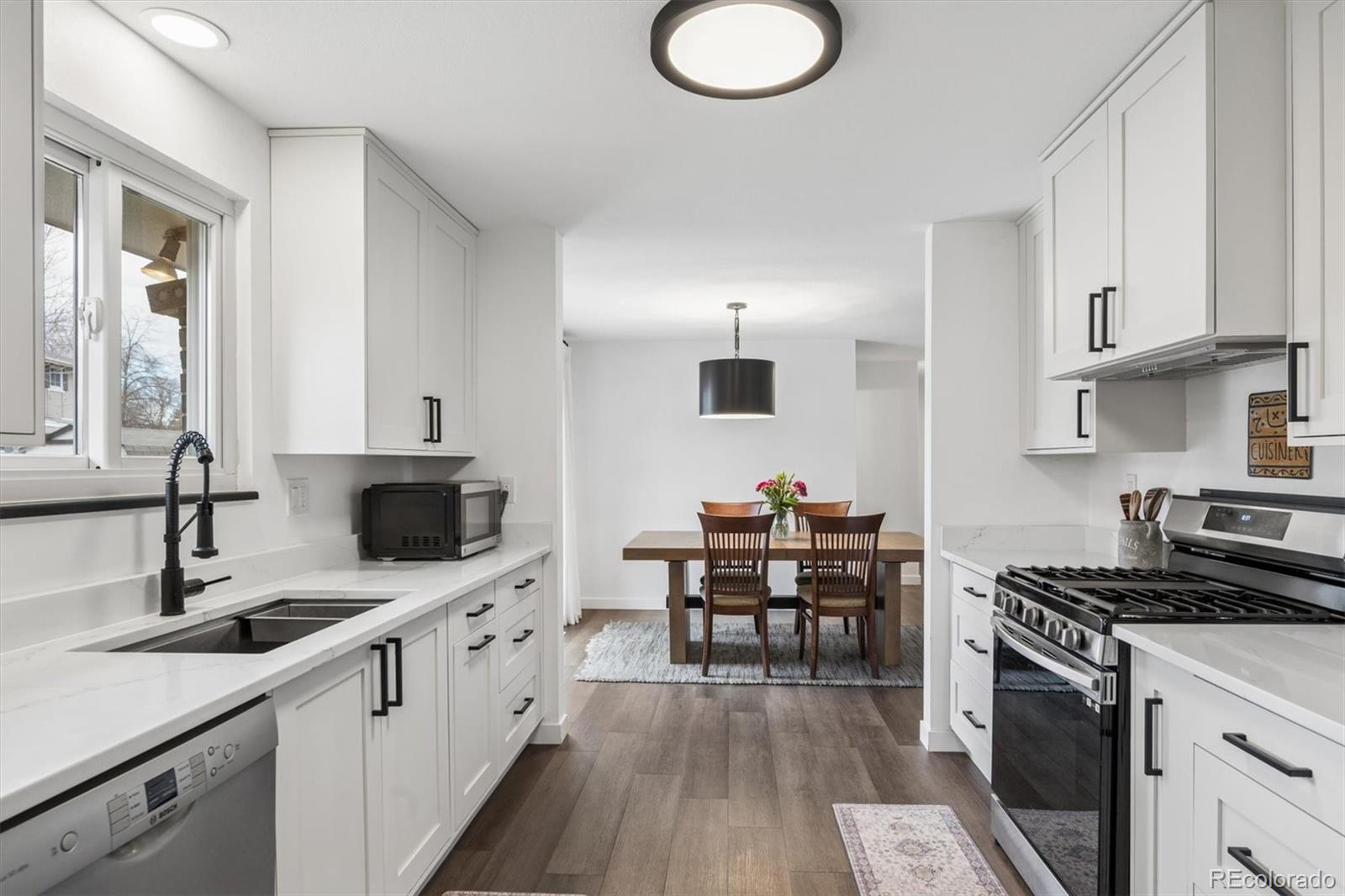 8257 Yarrow Court Arvada, CO 80005 - Photo 24 of 38 a kitchen with a sink stove and cabinets