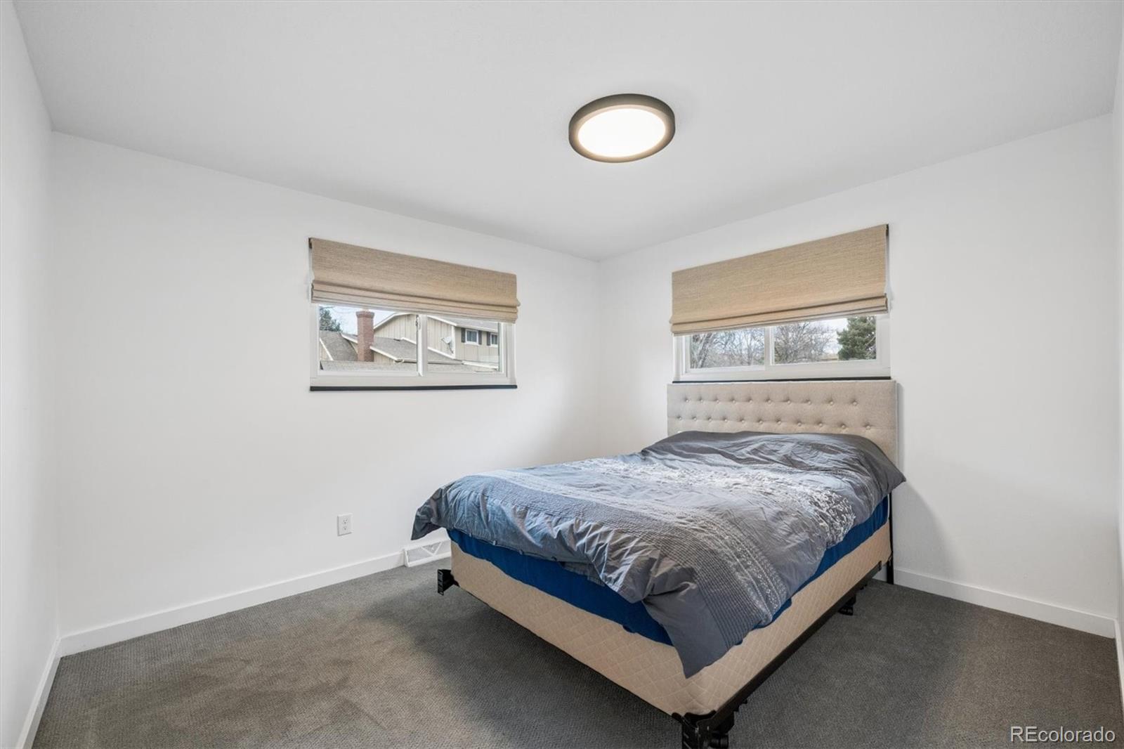 8257 Yarrow Court Arvada, CO 80005 - Photo 29 of 38 a bed sitting in a bedroom next to a lamp
