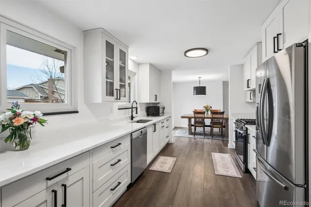 a kitchen with white cabinets and stainless steel appliances