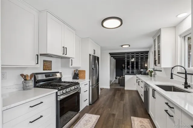 a kitchen with stainless steel appliances granite countertop a stove a sink and a refrigerator