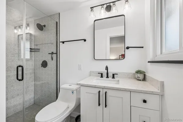 a bathroom with a toilet sink shower and mirror