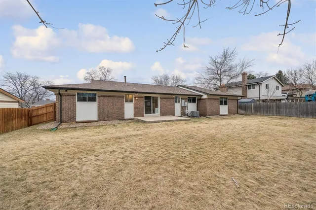 a front view of a house with a garden and trees