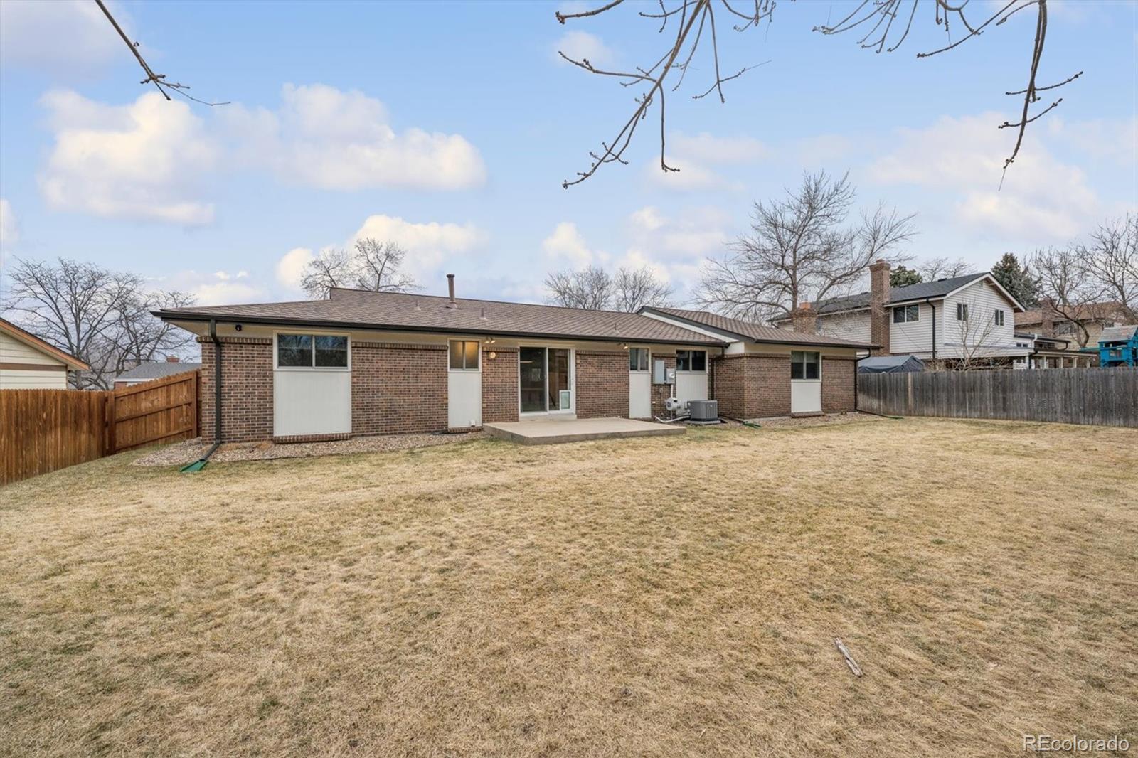 8257 Yarrow Court Arvada, CO 80005 - Photo 10 of 38 a front view of a house with a garden and trees