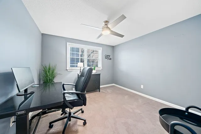 a view of a workspace with furniture and a window