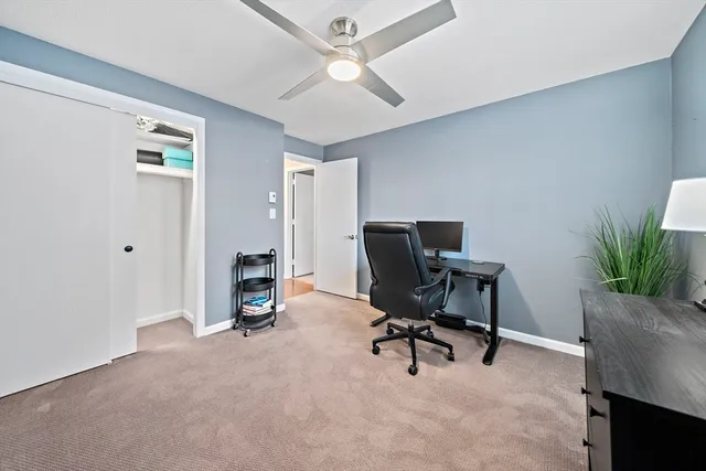 a view of a workspace with furniture and a window