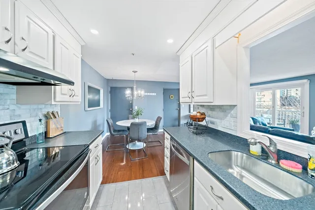 a kitchen with stainless steel appliances granite countertop a sink stove and cabinets