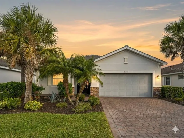 a view of house with a yard and palm trees