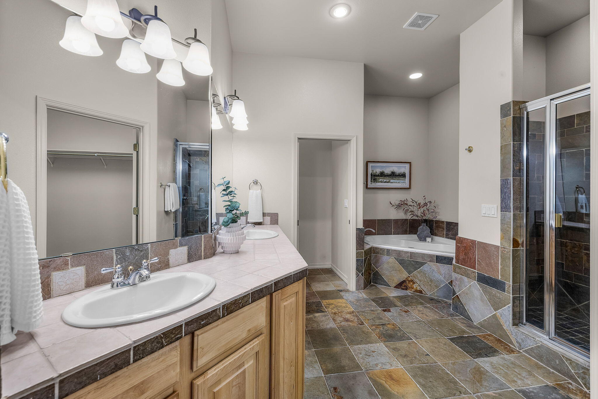 19571 Southwest Simpson Avenue Bend, OR 97702 - Photo 22 of 45 Primary bathroom suite with dual sinks, tiled shower, soaking tub, enclosed comode, and spacious closet.