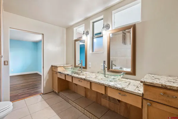 a bathroom with a granite countertop sink and a mirror