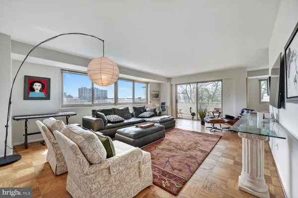 a living room with furniture a large window and a chandelier