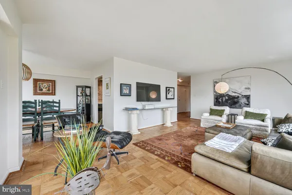 a living room with furniture a flat screen tv and a table