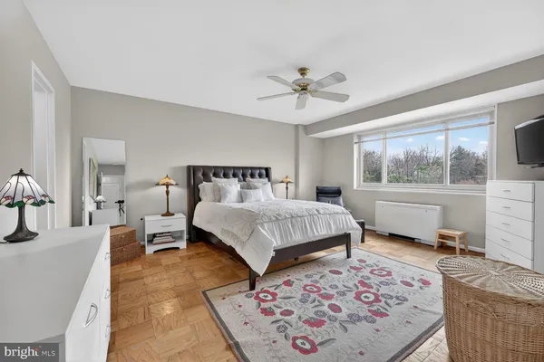 a bedroom with a bed wooden floor and window
