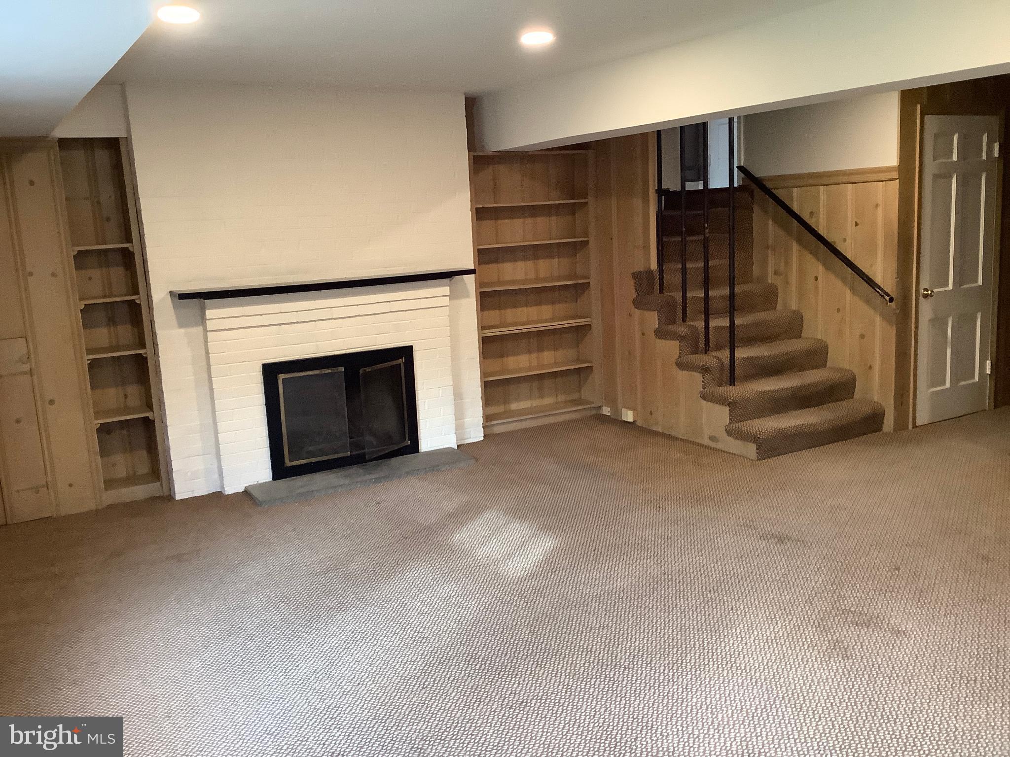 5702 Ogden Road Bethesda, MD 20816 - Photo 19 of 23 a view of an empty room with stairs and a fireplace