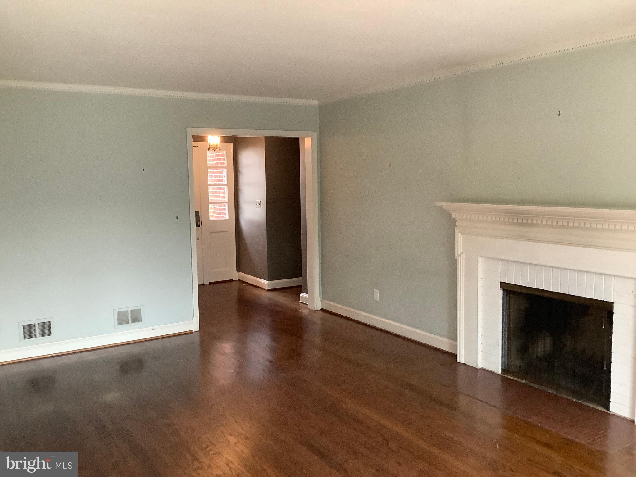 5702 Ogden Road Bethesda, MD 20816 - Photo 7 of 23 an empty room with wooden floor and fireplace