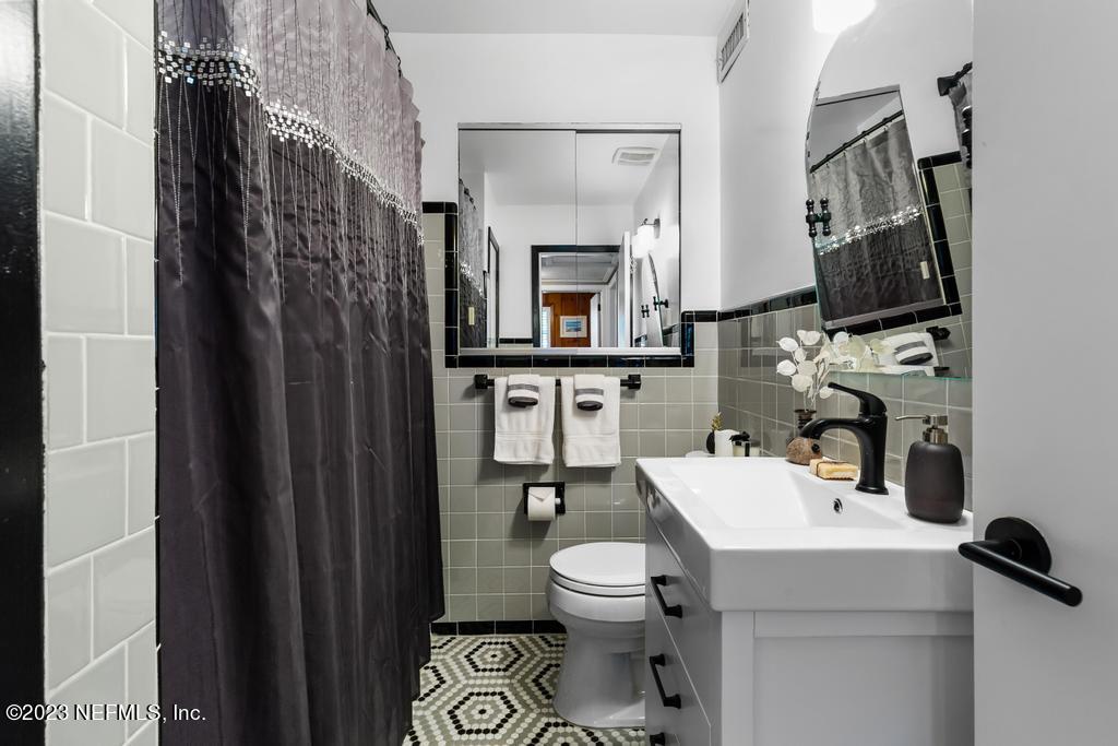 6712 E Road Jacksonville, FL 32216 - Photo 25 of 40 a bathroom with a toilet a sink and a mirror