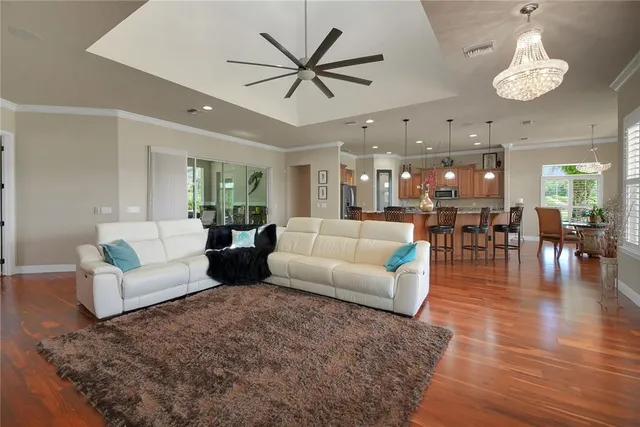 a view of a dining room and livingroom with furniture wooden floor a chandelier