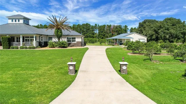 a living room with furniture kitchen view and a chandelier
