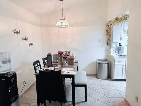 a dining room with a chandelier and wooden floor