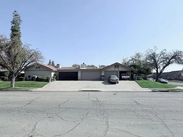 a white house with a yard and large trees