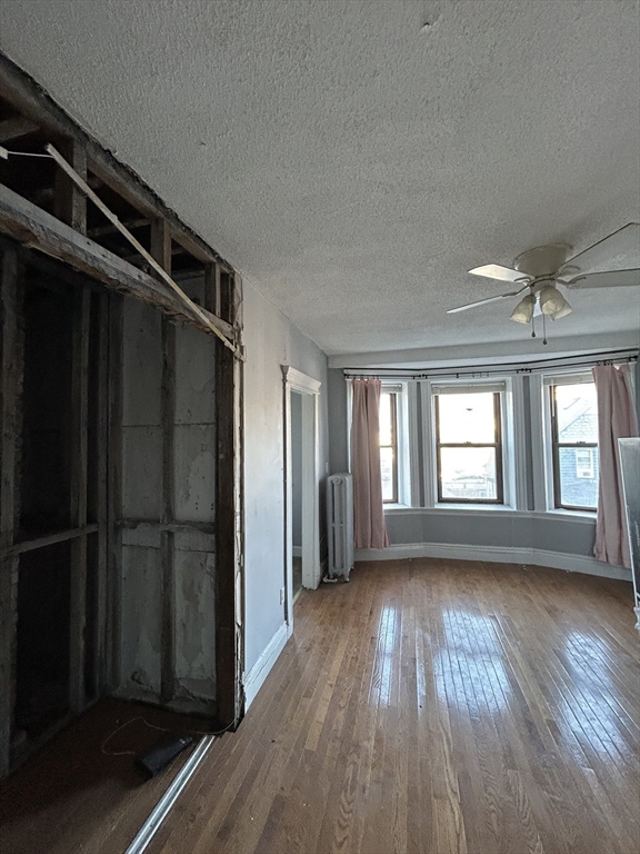 285 Lynn Shore Drive, Unit 308 Lynn, MA 01902 - Photo 3 of 11 an empty room with wooden floor cabinet and windows