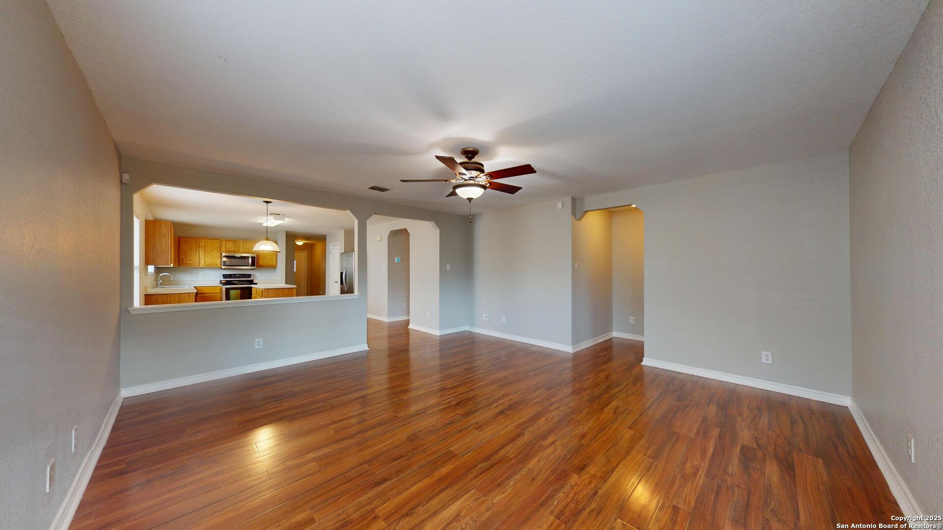 9515 Boatman Pier Converse, TX 78109 - Photo 16 of 41 a view of a livingroom with wooden floor and a ceiling fan