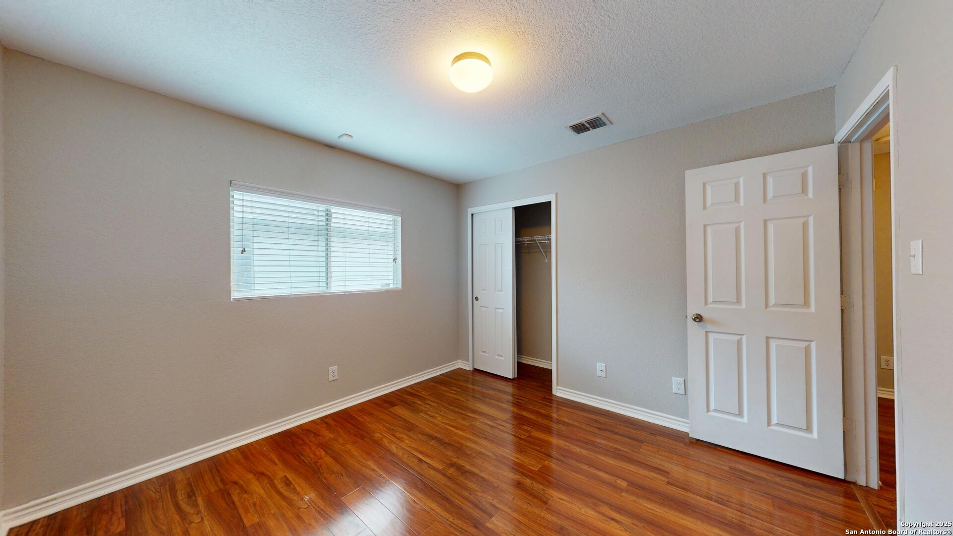 9515 Boatman Pier Converse, TX 78109 - Photo 19 of 41 an empty room with wooden floor and windows