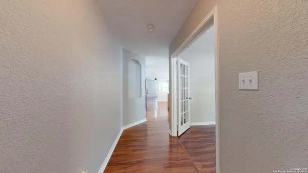 a view of a hallway with wooden floor