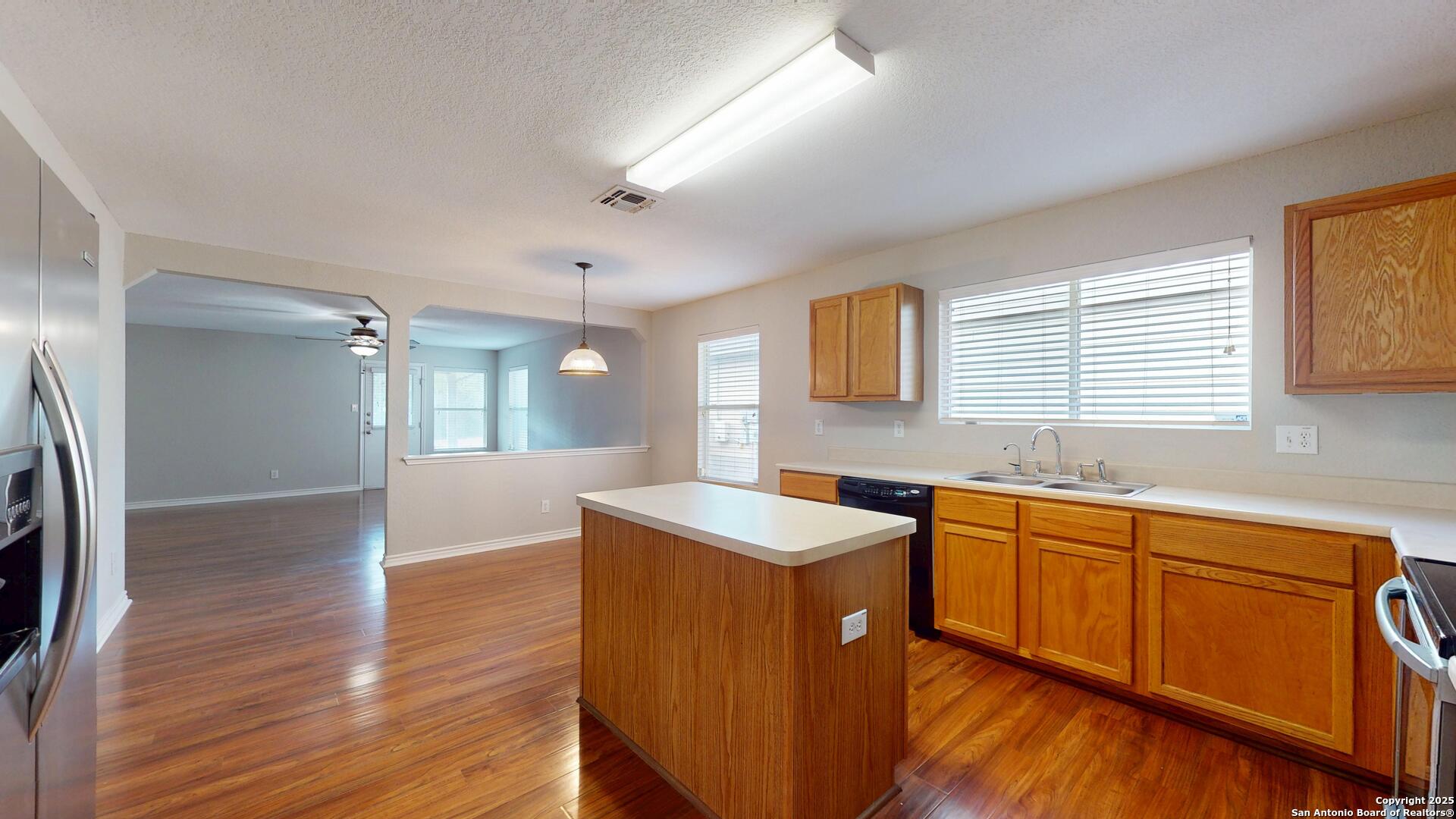 9515 Boatman Pier Converse, TX 78109 - Photo 7 of 41 a kitchen with stainless steel appliances granite countertop a sink a stove a refrigerator and island with wooden floor