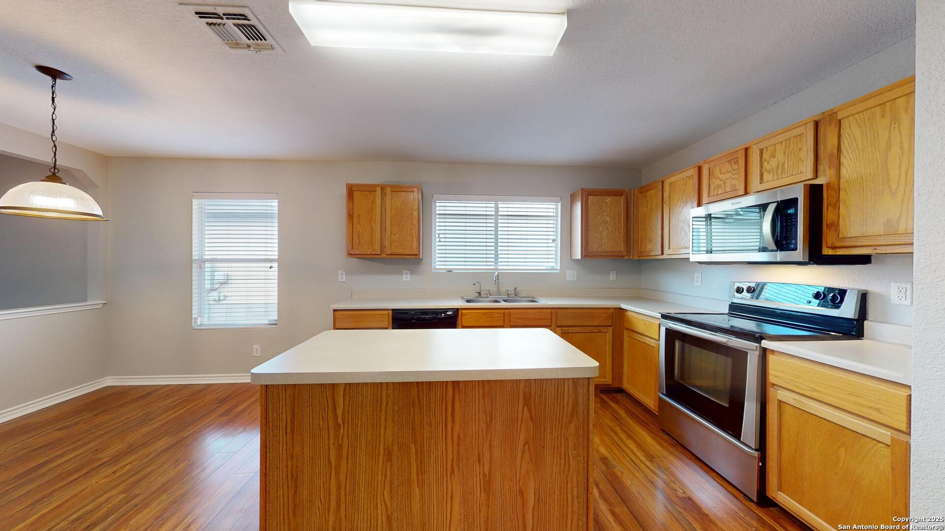9515 Boatman Pier Converse, TX 78109 - Photo 8 of 41 a kitchen with stainless steel appliances a stove a sink a microwave a refrigerator cabinets and a window