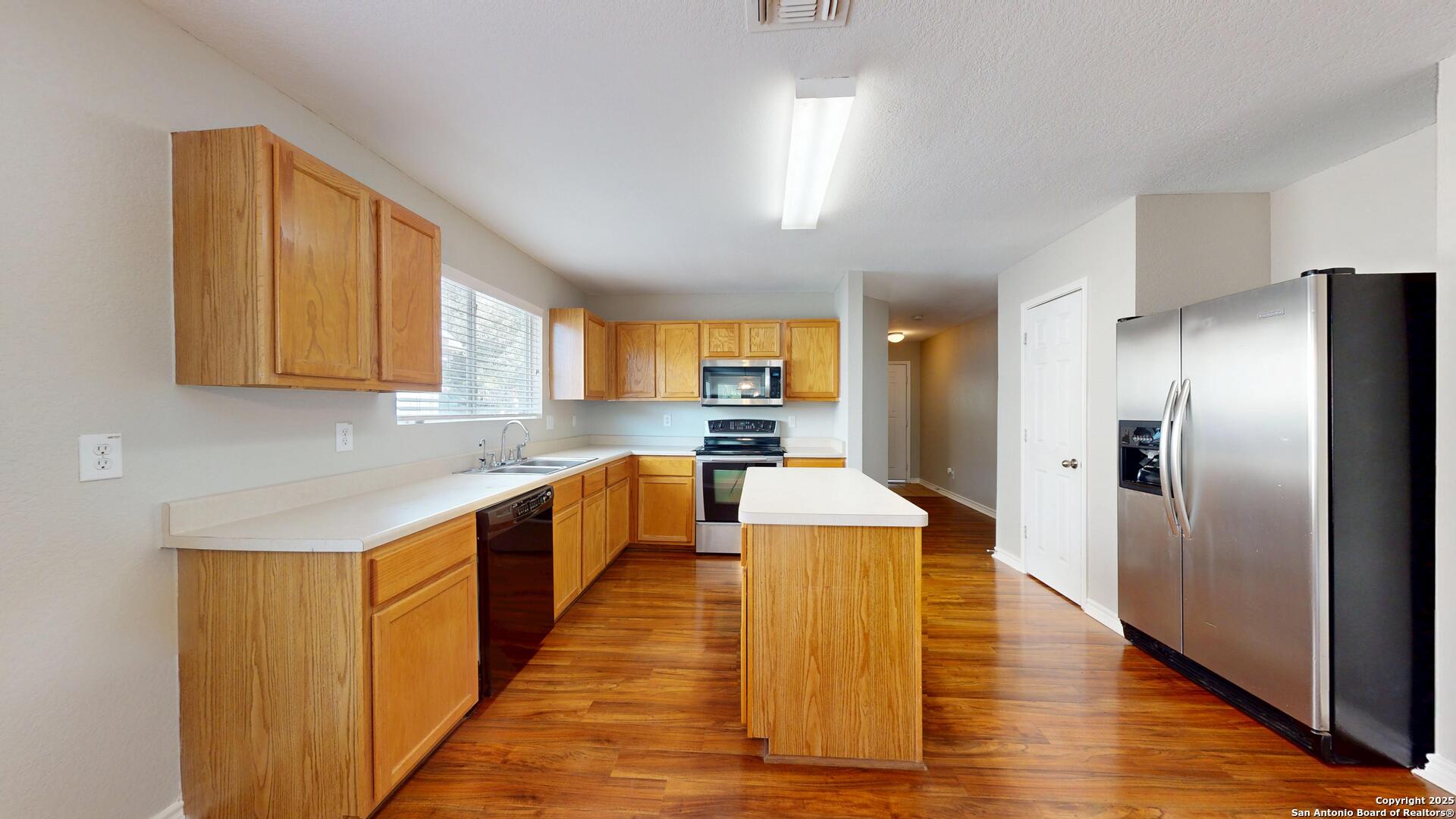 9515 Boatman Pier Converse, TX 78109 - Photo 10 of 41 a large kitchen with stainless steel appliances kitchen island granite countertop a large counter top and a refrigerator