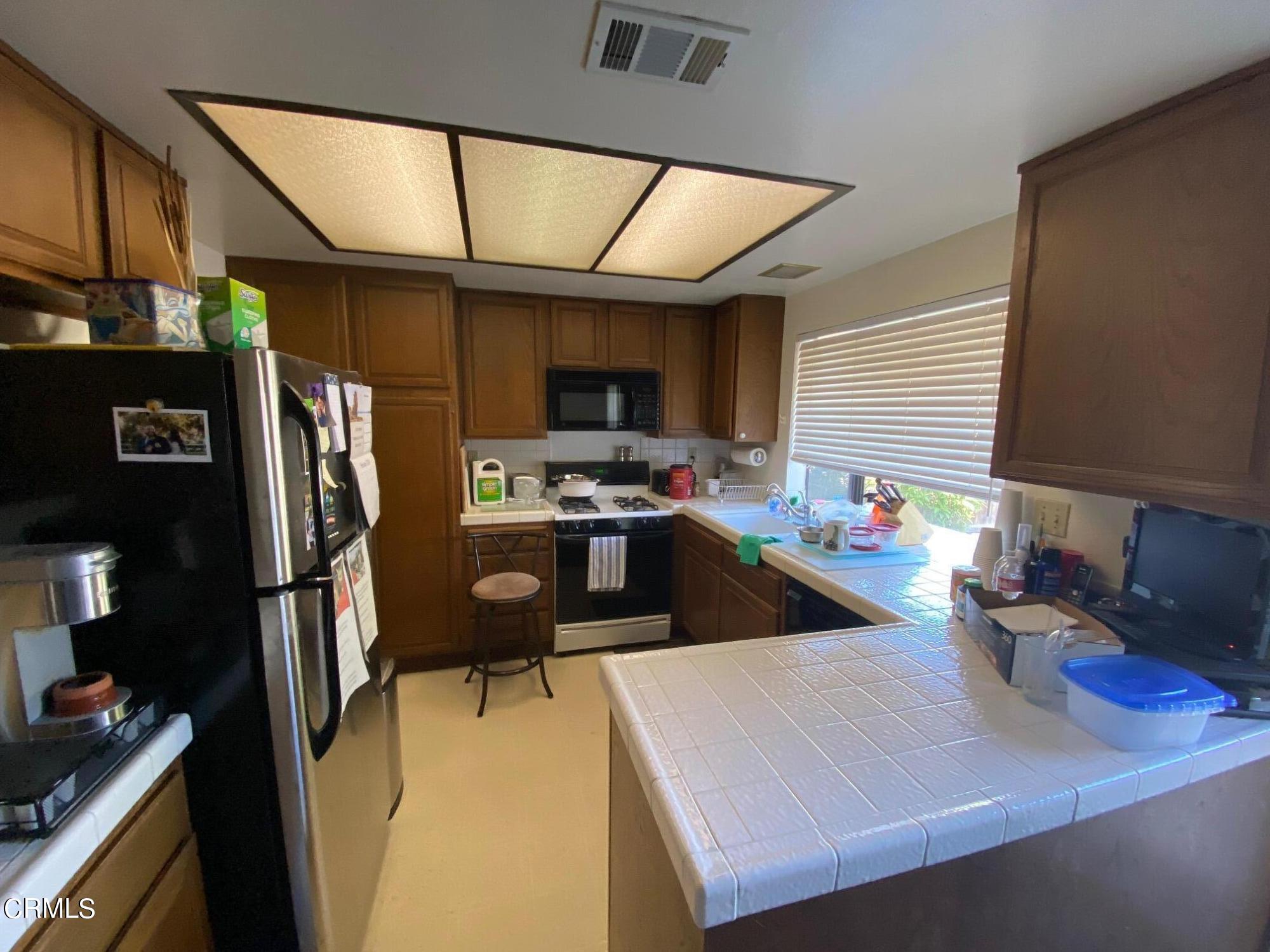 13657 Gunsmoke Road Moorpark, CA 93021 - Photo 4 of 26 a kitchen with refrigerator and stove