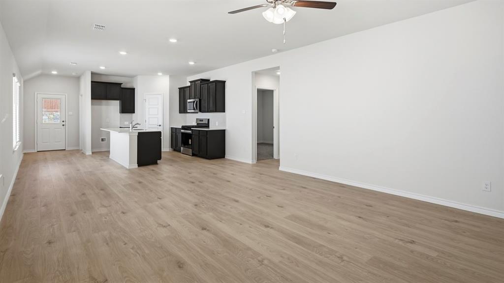 3513 Amaretto Road Aubrey, TX 76227 - Photo 32 of 34 a view of kitchen with stainless steel appliances kitchen island wooden floor and living room view