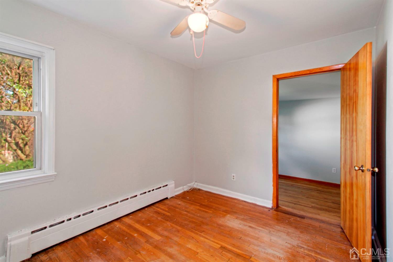 159 Vineyard Road Edison, NJ 08817 - Photo 7 of 30 a view of an empty room with wooden floor and a window