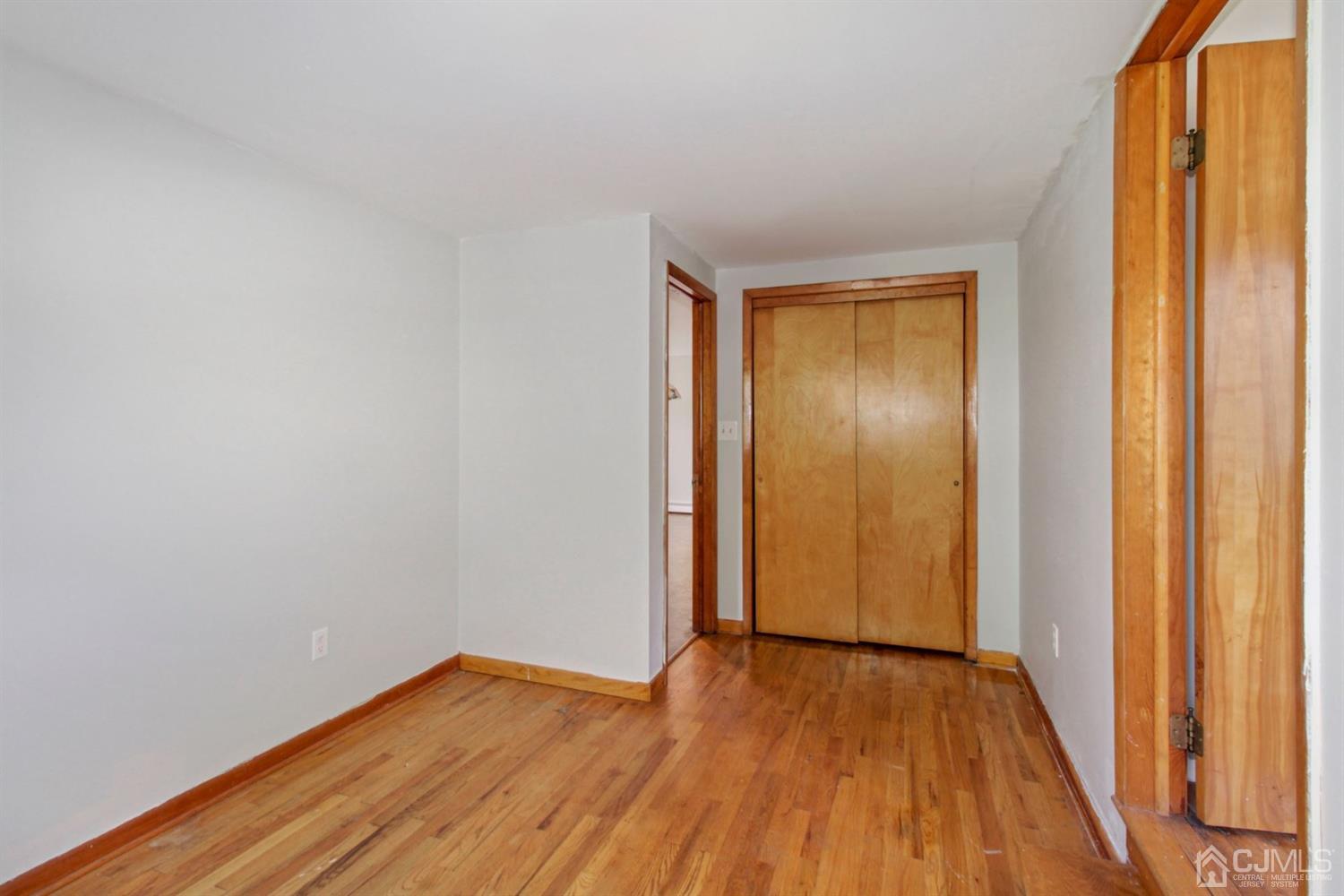 159 Vineyard Road Edison, NJ 08817 - Photo 8 of 30 a view of an empty room with wooden floor and a window